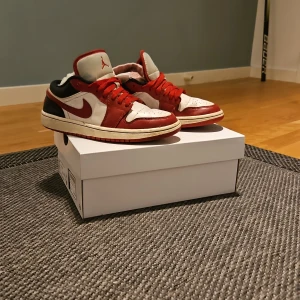Nike Air Jordans i rött och vitt - Snygga Nike Air Jordans i en klassisk röd och vit färgkombination. Skorna har en låg profil med snörning och den ikoniska swoosh-loggan på sidan. Perfekta för dig som vill ha en stilren och sportig look. Tvättas före frakt!