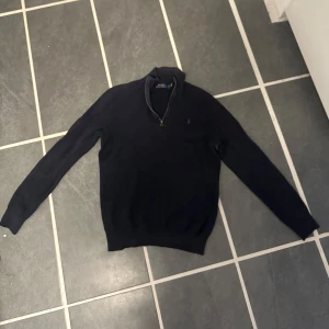 Ralph Lauren half zip - En stilren mörkblå Ralph Lauren half zip stl M, finns ett pyttelitet hål nästan längst ner på högerärmen som inte syns om man inte kollar riktigt nära, annars perfekt skick! Nypris 1599kr, mitt pris: 699kr
