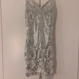 Silvrig klänning  - Silvrig fest klänning. Kort och sitter åt på kroppen. Säljer då den är för stor för mig 
