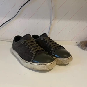 Lanvin  - Snygga gröna sneakers med en glansig tå och snörning. Skorna har en vit sula som ger en cool kontrast till det mörka tyget. Perfekta för en stilren look. Pris är ej hugget i sten kan även ta byte 