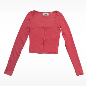 Rosa croppad kofta från JJXX - Säljer en söt rosa cropped cardigan från JJXX. Jag säljer den för att den är för liten för mig så jag har bara använt den två gånger. Den har långa ärmar och knappar framtill. Koftan är i en mjuk och skön bomullsmix. 🌸