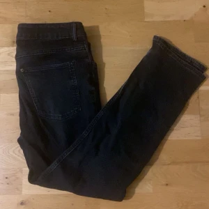 Svarta jeans - Snygga svarta jeansbyxor med klassisk femficksdesign. De har en dragkedja och knapp framtill. Perfekta för en stilren look. Den är i storlek 160 