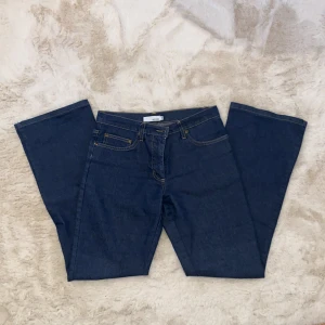 Blå jeansbyxor från Hennes - Snygga blå jeansbyxor från Hennes med klassisk design. Byxorna har en rak passform och är perfekta för en avslappnad stil. De har fem fickor och en knappgylf.