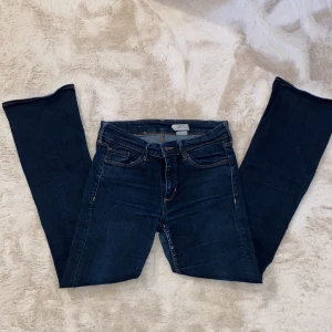 Mörkblå jeansbyxor från BLoyal (bootcut) - Snygga mörkblå jeansbyxor från BLoyal med klassisk femficksdesign och orange sömmar. Perfekta för en stilren look. De har en knapp och dragkedja framtill.