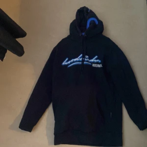 Hoodrich tracksiut - Säljer en mörkblå tracksiut från Hoodrich med blå och vit logga på bröstet. Den har en klassisk design med dragsko i huvan och ribbade muddar vid ärmslut och nederkant. Perfekt för en avslappnad stil. Priset kan diskuteras först till kvarn 