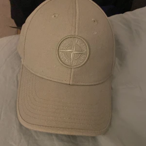 Stone Island Keps - Kepsen är i väldigt bra skick utan några skador eller fläckar osv. Kepsen är i junior storlek och det står att det är storlek 3 i kepsen. Den är självklart äkta och köpt på nk i Stockholm.
