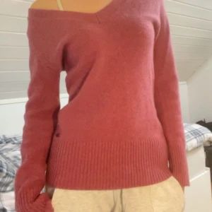 Rosa stickad tröja med v-ringning - Säljer en supermysig rosa stickad tröja med v-ringning. Den har långa ärmar och ribbade muddar som ger en skön passform. Perfekt för höst och vinter när du vill hålla dig varm och stilren. Tröjan är i mycket bra skick och redo för nya äventyr!
