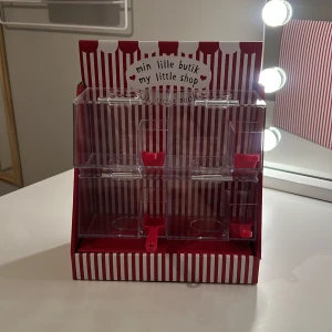 Liten godisbutik 🍬🍭 - Det här är en liten godisbutik som man kan ha smågodis i! På sidan av finns skopor som du kan skopa up ditt godis med. För att fylla den med godis kan du öppna där fram. Varan har alldrig används. Original pris: 164kr tror jag 
