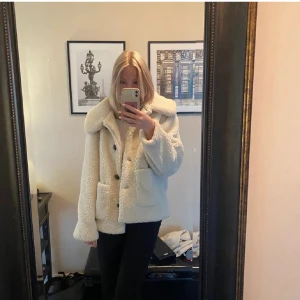 Beige teddyjacka - Mysig beige teddyjacka i mycket bra skick. Perfekt för höst och vinter med sina långa ärmar och stora knappar. Jackan har en loose passform och två praktiska fickor framtill. Superchill och varm för kalla dagar! 🧥✨