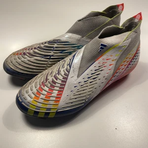 Färgglada fotbollsskor - Säljer ett par riktigt coola fotbollsskor i syntetmaterial med en massa färger som blå, röd, gul och orange. De har en tight passform och är perfekta för fotboll. Skorna har en unik design med mönster och detaljer som verkligen sticker ut på planen. Skorna e köpta för 3200kr men i snabb affär kan priset sänkas. Inget följer med bara skorna.🫡🫡