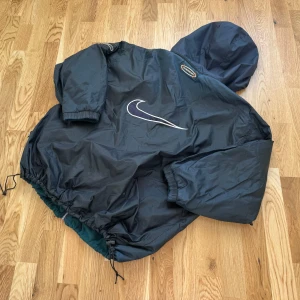RARE 1995 Nike ACG Storm Fit vändbar jacka/fleece - En snygg och bekväm jacka som är mkt sällsynt. Vändbar så kan användas som jacka eller fleece. Avtagbar huva. Svart jacksida, mörkgrön fleecesida. Storlek L.