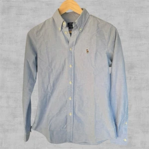 Ralph Lauren Skjorta - Ralph Lauren Skjorta med färglad häst. I bra skick med små täcken på användning. Finns en liten defekt på ena armbågen. Storlek S men sitter något mindre och är tajt i storleken. Passar mer som XS.  Ställ gärna frågor vid funderingar!