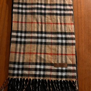 Burberry halsduk - Burberry halsduk bra skick! Den är tyvärr inte min stil längre så därför säljer jag denna  Priset är inte hugget i sten och kan absolut diskuteras vid snabb affär