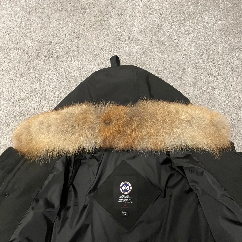 Säljer en svart Canada Goose dunjacka i mycket bra skick. Jackan har en avtagbar päls på huvan och är perfekt för kalla vinterdagar. Den är långärmad med dragkedja och knappar framtill. Supervarm och stilren! Helt ny . Jackor.