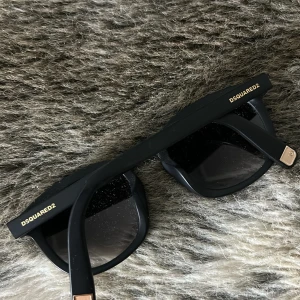 DSQUARED2 Solglasögon  - Snygga svarta solglasögon från DSQUARED2 i klassisk stil. Köpta för några år sedan men bara legat och skräpat, använda några gånger men annars i nyskick! Boxen har tyvärr försvunnit och därför säljs dom till ett billigare pris. 