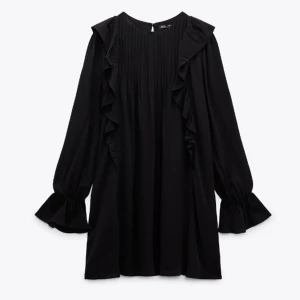 Svart klänning med volangdetaljer - Snygg svart klänning från Zara med långa ärmar och volangdetaljer längs fram- och baksidan. 