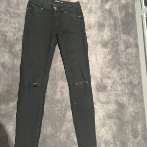 Svarta skinny jeans med slitningar - Säljer ett par svarta skinny jeans i bra skick. De har coola slitningar på knäna och en medium hög midja för en snygg passform. Perfekta för både vardag och fest! 🖤