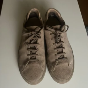 Axel Arigato skor - Säljer ett par snygga Axel arigato skor. Säljer för att dom börjar bli lite små. Skorna är i väldigt bra skick förutom ett litet hål som man ser på bilden. Har inte kvar boxen eller påsen.