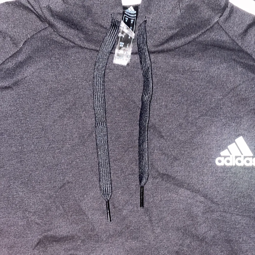 Säljer en svart hoodie från Adidas i mycket bra skick. Den har de klassiska tre vita ränderna längs ärmarna och Adidas-loggan på bröstet. Perfekt för både träning och vardag. Superbekväm och stilren design!. Tröjor & Koftor.