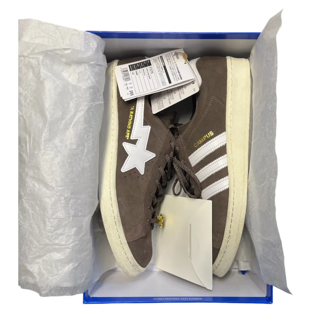 Bruna sneakers i samarbete mellan Adidas och Bape. Extremt bra skick,använda 1 gång .De har en cool stjärndetalj på sidan och klassiska vita ränder. Skorna är i mocka. Kommer i originalförpackning med extra skosnören och en bape x adidas shoebag(bild 5). Storlek 44 1/2.. Skor.