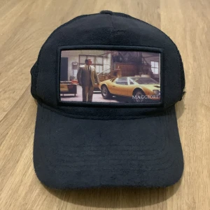 Svart keps med bilmotiv - Snygg svart keps från Maggiore med ett coolt bilmotiv på framsidan. Kepsen har en nätbaksida för bra ventilation och en justerbar rem för perfekt passform. Perfekt för sommarens alla äventyr! Den är helt äkta och den är en fräsch och ny limited edition maggiore.