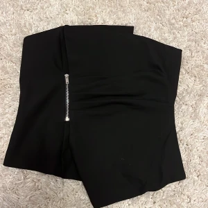 Fest topp - Svart omlott-topp med dragkedja och knapp på insidan. Använd 2 gånger. Nyskick. Storlek M men passar mer som en S skulle jag säga