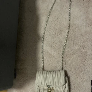 Vit quiltad axelväska från Pepe Moll - Säljer en superfin vit quiltad axelväska från Pepe Moll. Väskan har en elegant kedjerem och ett snyggt spänne framtill. Perfekt för både vardag och fest! 👜✨