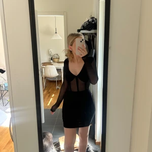 Svart klänning - Svart fin klänning som är genomskinlig på magen och ärmarna. Storlek XS