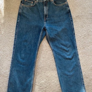 Blå jeans från Weekday - Säljer ett par snygga blå jeans från Weekday i modellen Rowe extra high straight. De har en klassisk femficksdesign och är i mycket bra skick. Perfekta för både vardag och fest! 🕺