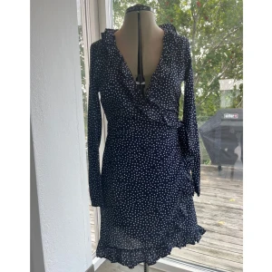 Blå prickig klänning - Superfin prickig omlottklänning i storlek S. Använd men i mycket bra skick.