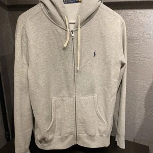 Ralph lauren hoodie - Grå ralph lauren zip hoodie i oanvänt skick, storlek M