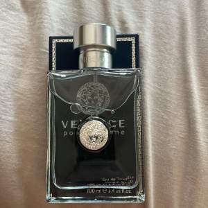 Säljer en elegant och stilren Versace Pour Homme Eau de Toilette. Flaskan är genomskinlig med en silverfärgad kork och har Versaces ikoniska medusamärke på framsidan. Parfymen är 100 ml och kommer i en snygg svart kartong med gulddetaljer. Perfekt för den som vill dofta lyxigt och fräscht! Säljer sampels på 5 ML