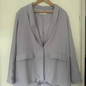 Ljuslila Kostym sett från Nelly Trend  - Ett ljuslila kostymsett från Nelly Trend i jättebra skick. Endast använt två gånger. Finns dessutom en extra knapp som ni ser på bilden. Passformen är lite oversized, men är i storlek 44 i både kavaj och byxa. 
