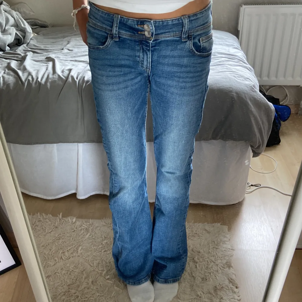 Säljer ett par snygga blå jeans från Gina Tricot. De har en perfekt längd (är 163 cm) och är lågmidjade med en bootcut-stil. Jeansen är i jättefint skick och redo för en ny ägare!. Jeans & Byxor.