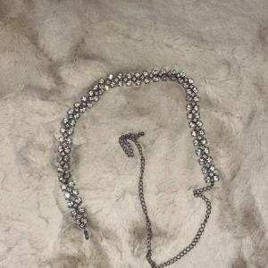 Silvrigt bälte med stenar från Glitter - Ett jättefint silvrigt bälte med stenar, perfekt runt en klänning!