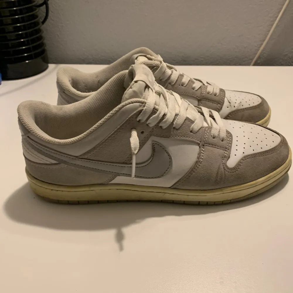 Nike dunk i grå färg, de är använda och i ganska dåligt skick men har lite kvar att ge. Sulan och tungan är i dåligare skick, pris kan diskuteras. Storlek 42-43. Skor.