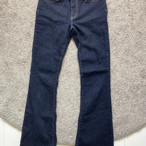 Mörkblå jeans med bootcut - Säljer ett par snygga mörkblå jeans med bootcut. De har en klassisk femficksdesign och är gjorda i ett slitstarkt denimtyg. de har bruna sömmar och är slutsålda på Gina tricos hemsida. Jeansen är i nyskick utan fläckar!💗Nypris 499