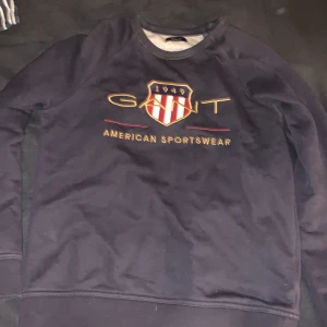 Mörkblå sweatshirt från GANT - Säljer en snygg mörkblå sweatshirt från GANT med tryck framtill. Tröjan har långa ärmar och rund halsringning. Perfekt för en avslappnad stil. Passar bra till jeans eller chinos. Perfekt skick!