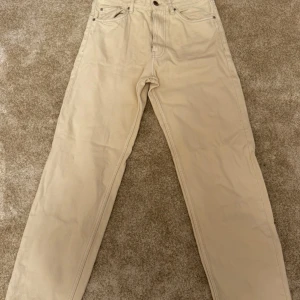 Beige jeansbyxor från Bershka - Missa inte chansen till denna populära byxa. Beige, vida byxor från Bershka. Byxorna har en avslappnad passform och är i storlek 34. Fick många kommentarer för dess sköna byxor. Säljes då jag vuxit ur dem.  Varumärke: Bershka Storlek: 34 (29) Ord. Pris: 399 Färg: Beige Skick: Mycket bra   Din stil: spara inlägget så du inte missar denna kappa Inte din stil: Kolla min profil. Du kommer hitta något för alla kön och åldrar.