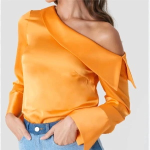 Orange offshoulder blus - Snygg orange blus i satin med offshoulder-design och långa ärmar. Andrea hedenstedt x nakd som ny