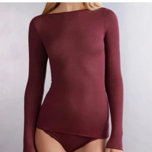 Vinröd långärmad topp - Snygg vinröd långärmad topp med en tight passform. Perfekt för lager-på-lager eller att bära som den är. Enkel och stilren design som passar till många olika outfits. Använd enstak gånger.