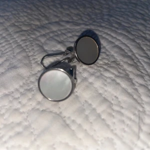 Runda silverörhängen - Snygga runda örhängen i silver med en slät yta. De har en enkel och elegant design som passar perfekt för olika tillfällen. Örhängena har en praktisk stängning som gör dem lätta att bära.