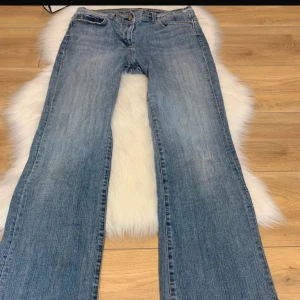 Blå jeans med broderade bakfickor - Snygga lågmidjade blå jeans med bootcut-stil och broderade detaljer på bakfickorna. Pris kan diskuteras vid snabb affär!