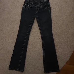  Miss Me jeans - Snygga mörkblå bootcut jeans från Miss Me med dekorativa broderier på bakfickorna. Liten defekt (se bild 5) men verkligen inget man tänker på! Midjemått 33x2=66 så 66cm och innerbenslängd 81cm!!❤️❤️❤️Har vanligtvis 25 i midja så dessa är små i midjan då det är vintage!💞verkligen så så snygga💞
