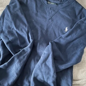 Blå tröja från Polo Ralph Lauren - Säljer en marinblå Polo Ralph Lauren tröja. Endast använd ett par gånger sä den är i riktig bra form