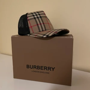  Burberry keps - Snygg keps från Burberry, aldrig använd då den inte passar mig och är nyligen köpt så den har inga skador eller så. Med köper tillkommer box och dustbag! VID SNABB AFFÄR KAN MAN FÅ BRA PRIS!!