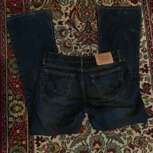 Levi's 529 jeans - Säljer ett par snygga bootcut lågmidjad mörkblå Levi's 529 jeans. smått slitet vid hälen men inget som syns. midjemått rakt av: 37cm   innerben: 77cm (tvättas innan post) 