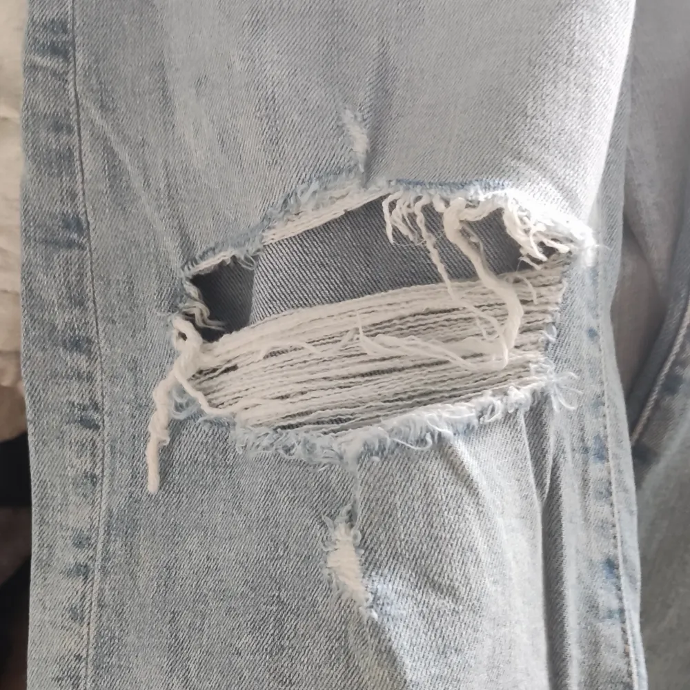 Säljer ett par ljusa jeans från Cubus i storlek XS. De är högmidjade och har en wide fit, vilket ger en skön och avslappnad look. Jeansen har coola slitningar på knäna som ger dem en trendig touch. Perfekta för både vardag och fest! . Jeans & Byxor.