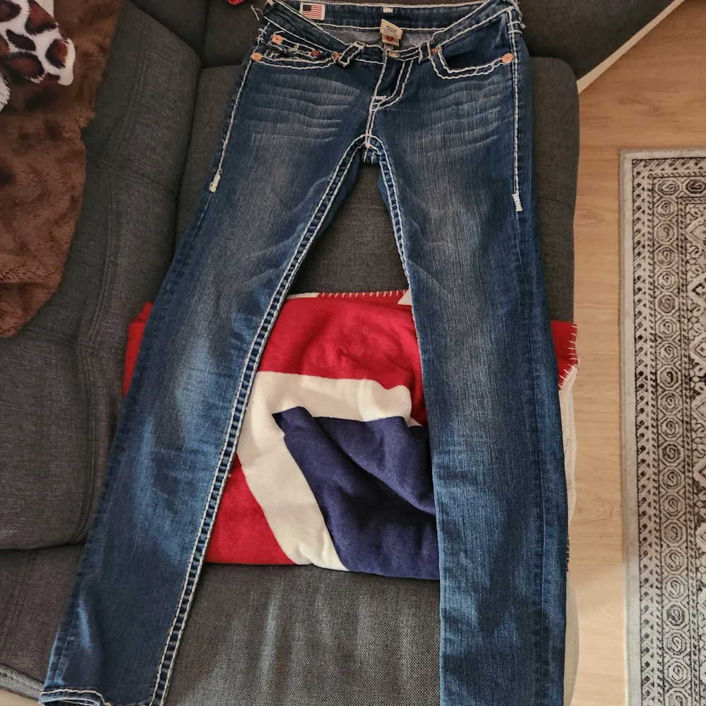 Säljer ett par snygga jeans från True Religion (storlek 28). De har en cool kontrastsöm och klassiska femficksdesign. Jeansen är väldigt low waist, tyvärr är tyget inte så töjbart. Skulle inte rekomendera att köpa om du har lite störe lår elle bakdel. Jeans & Byxor.