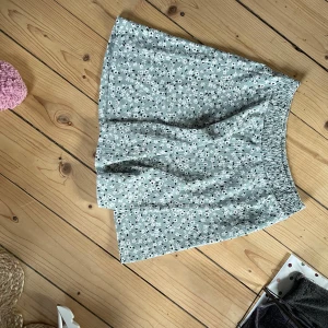 Kjol med blommor - Aldrig använd, stl M/L, blommor och knälång